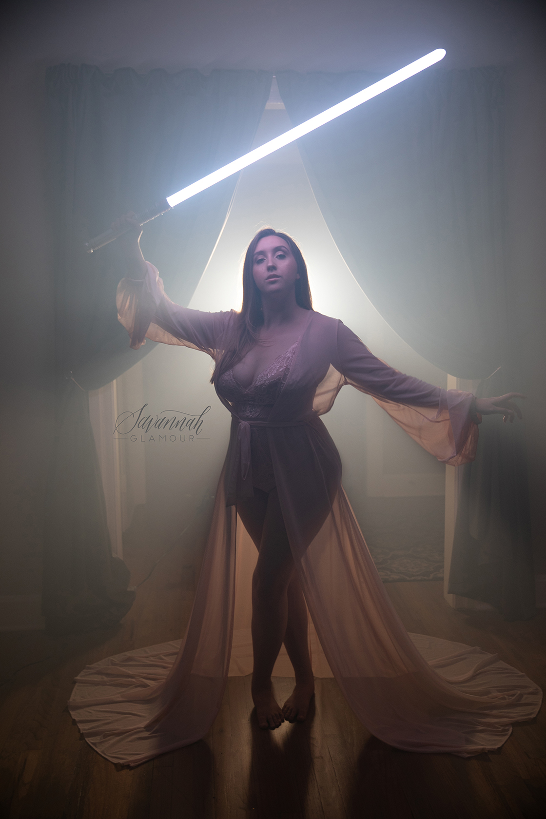 woman in sheer dress posing with lightsaber in her hand