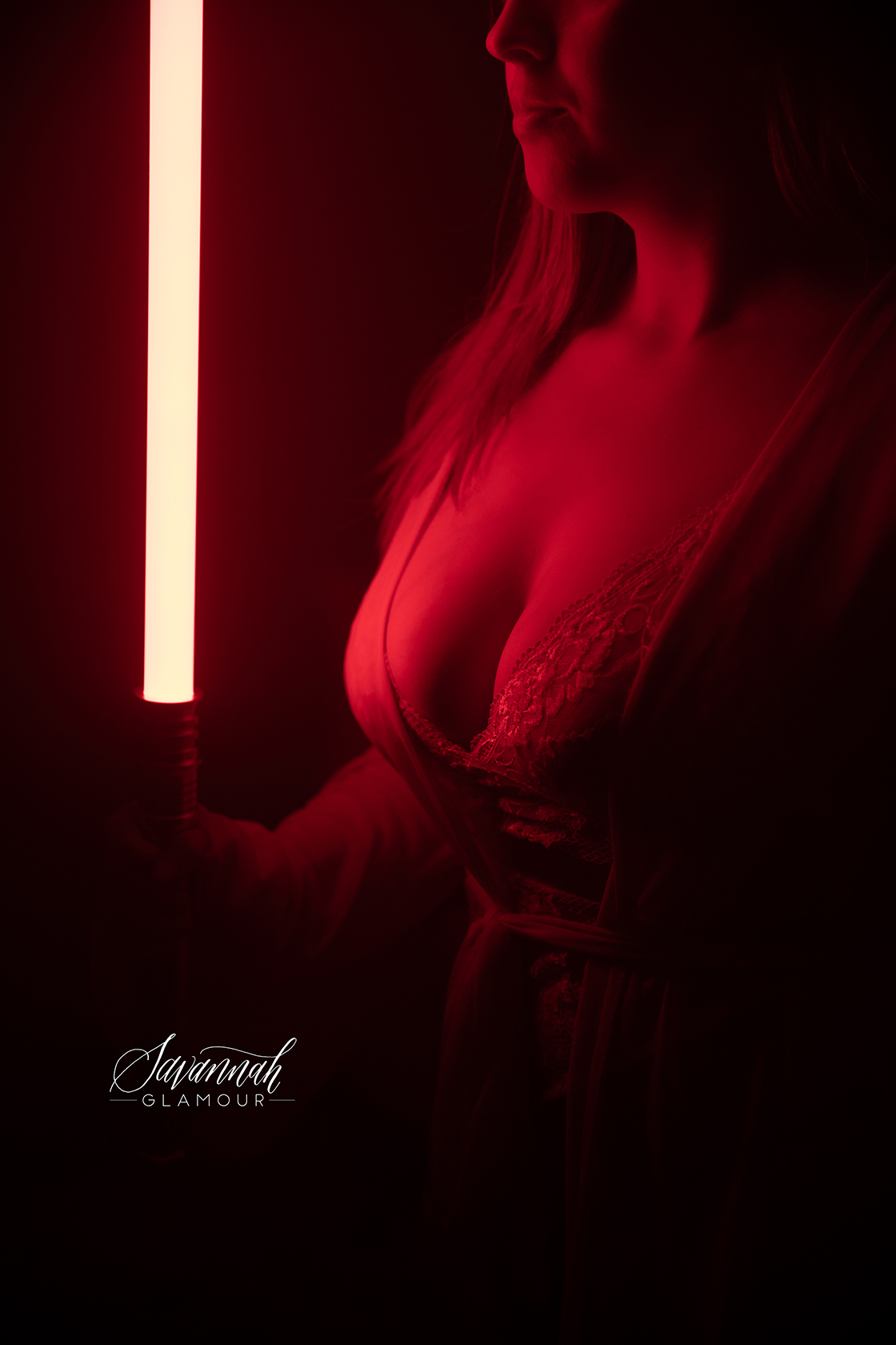 woman's chest wearing lingerie holding a lightsaber