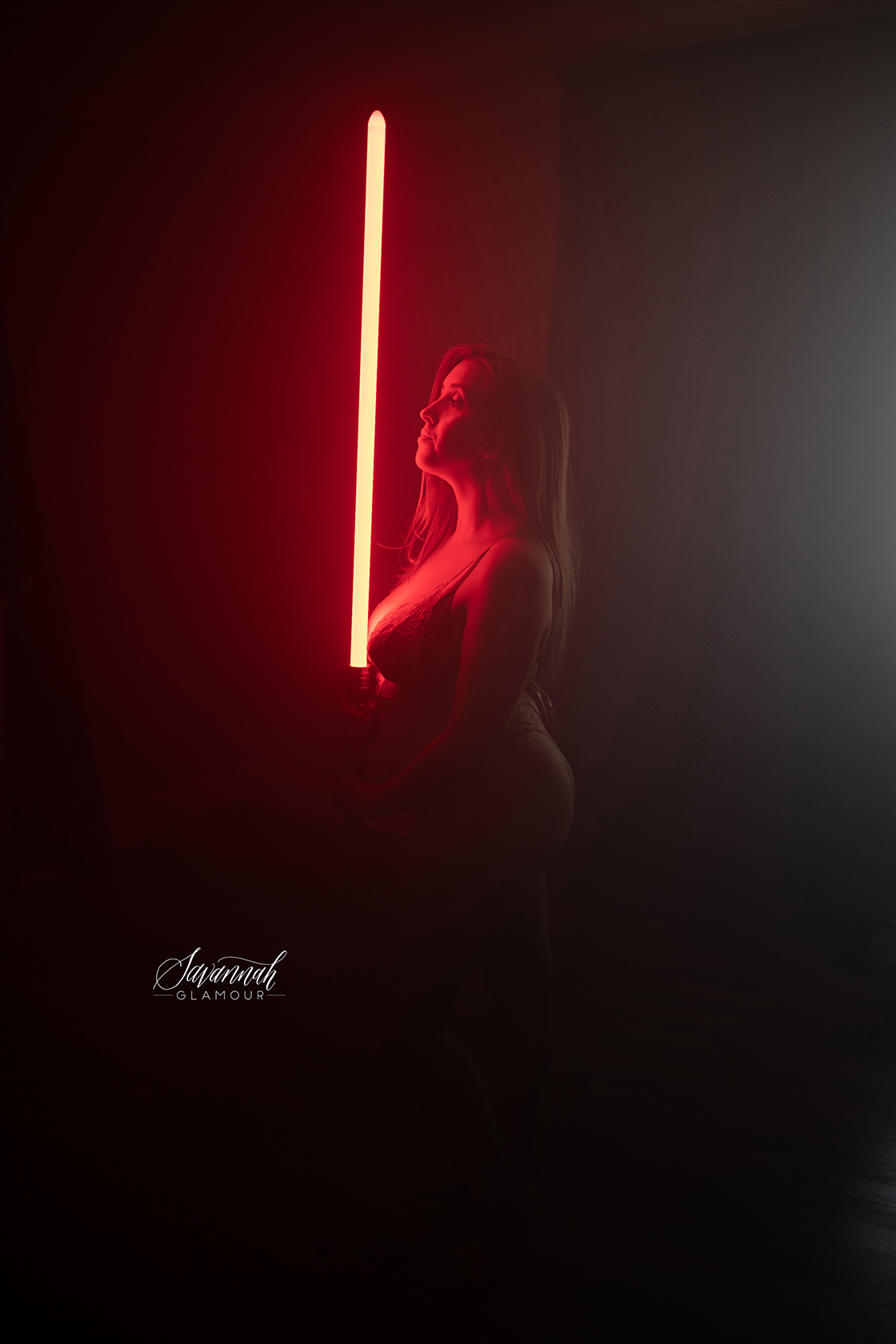 portrait of woman in lingerie holding a lightsaber