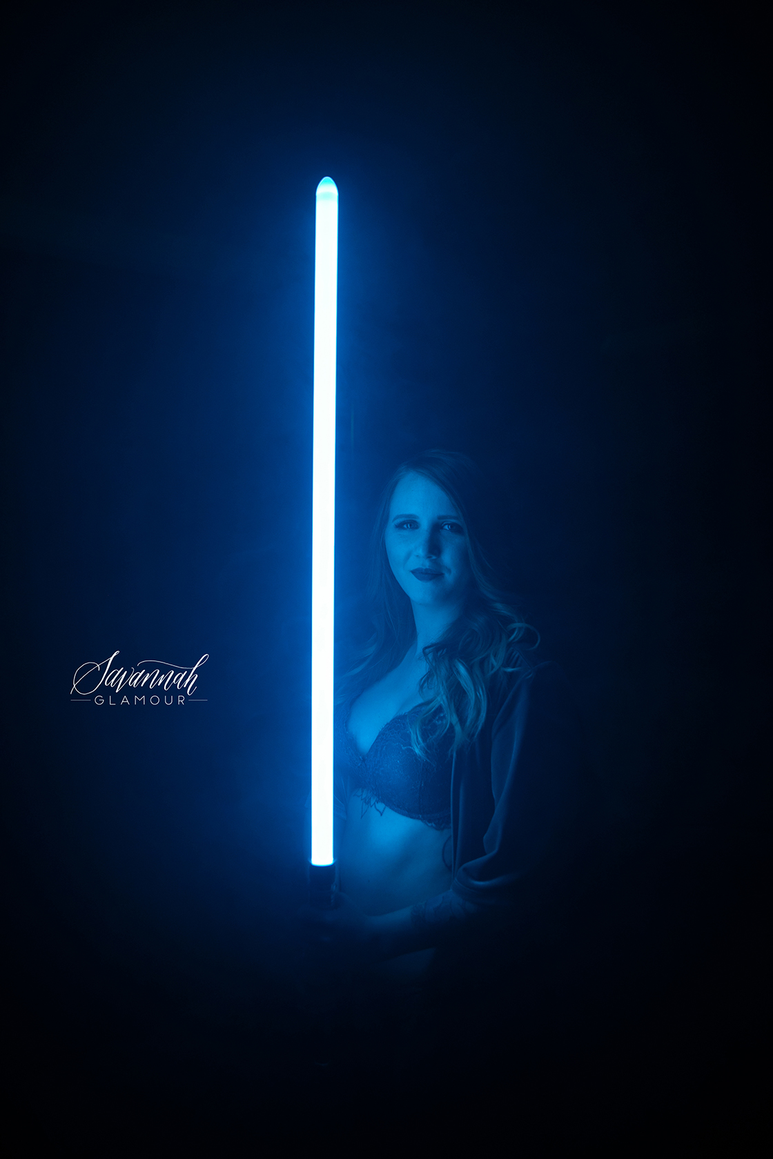 woman posing with a lightsaber in lingerie