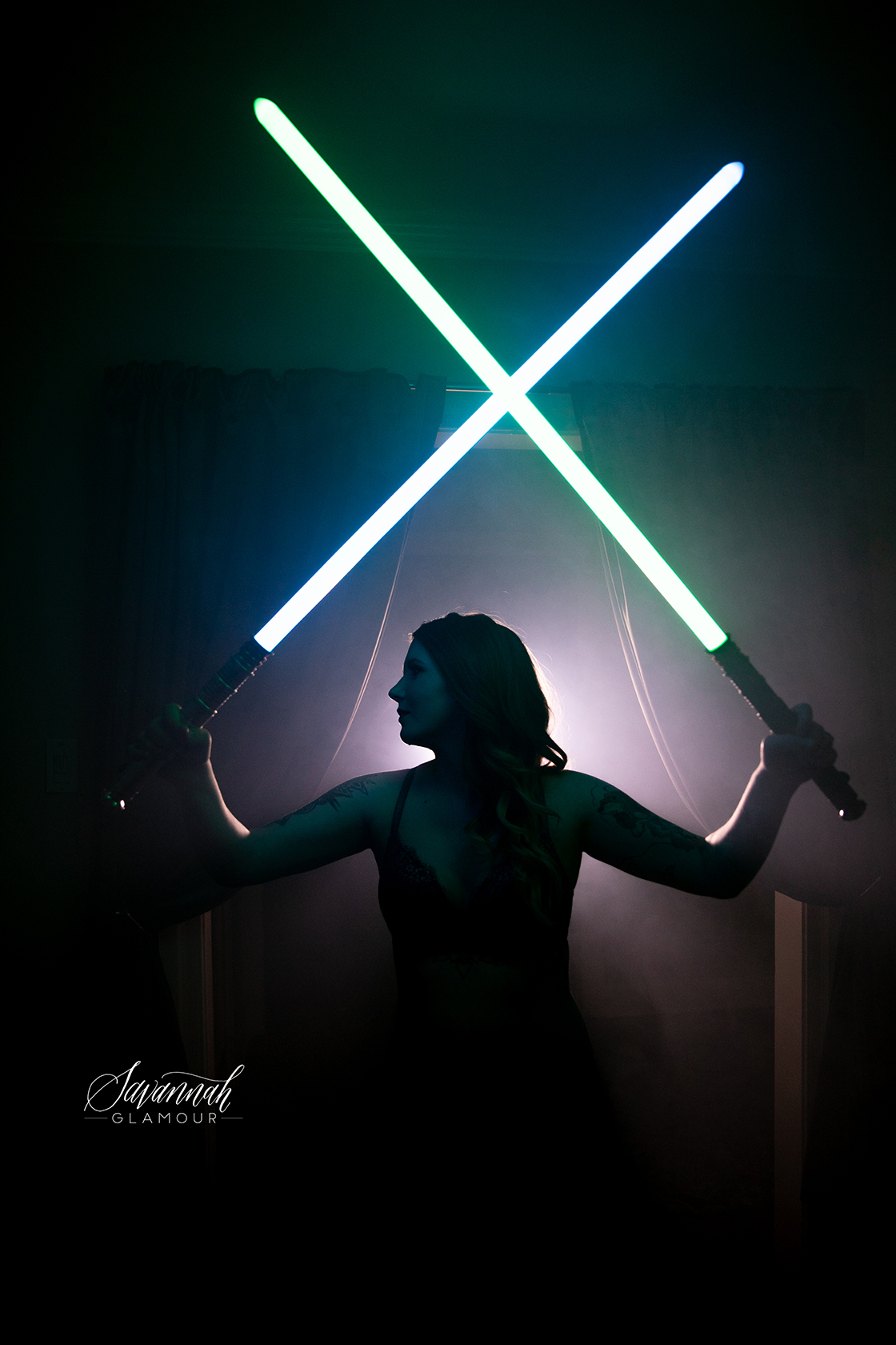 portrait of a woman holding two lightsabers overhead
