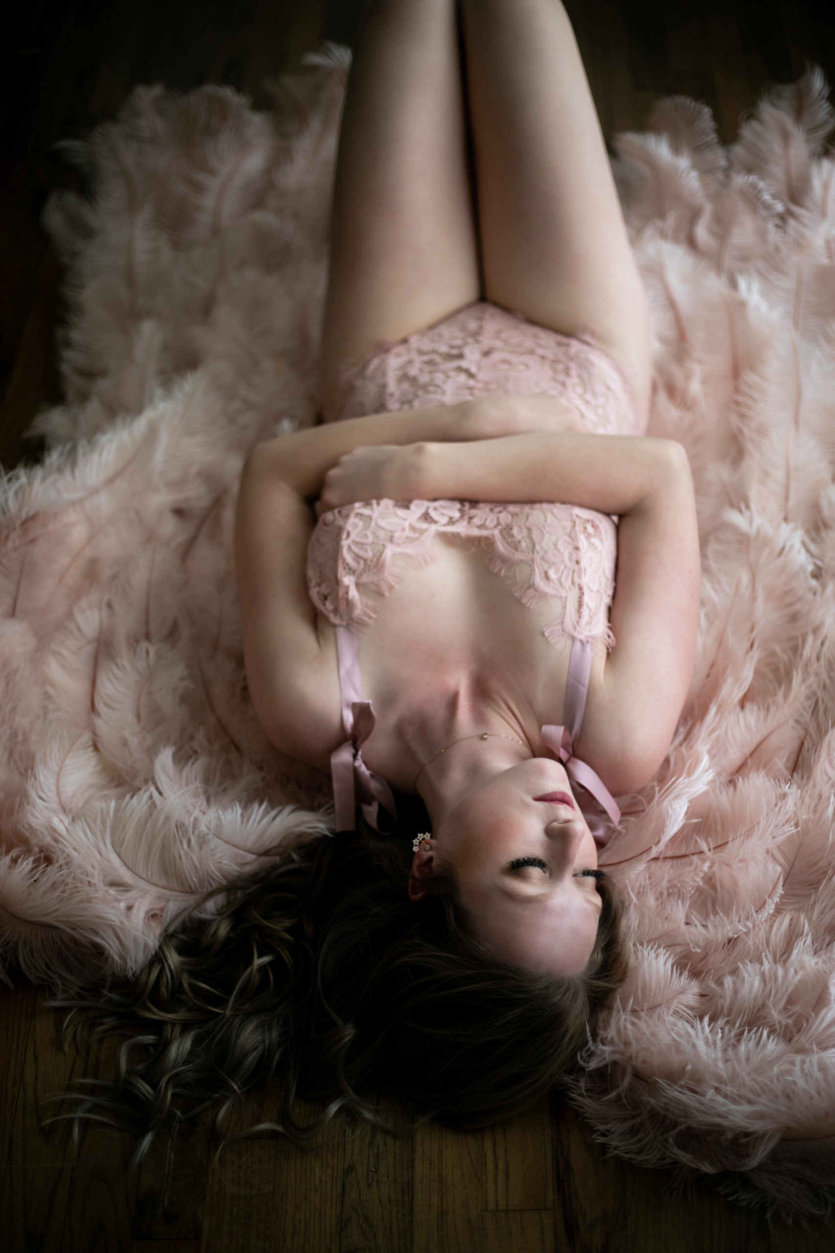 woman in pink lingerie and angel wings lying on the floor