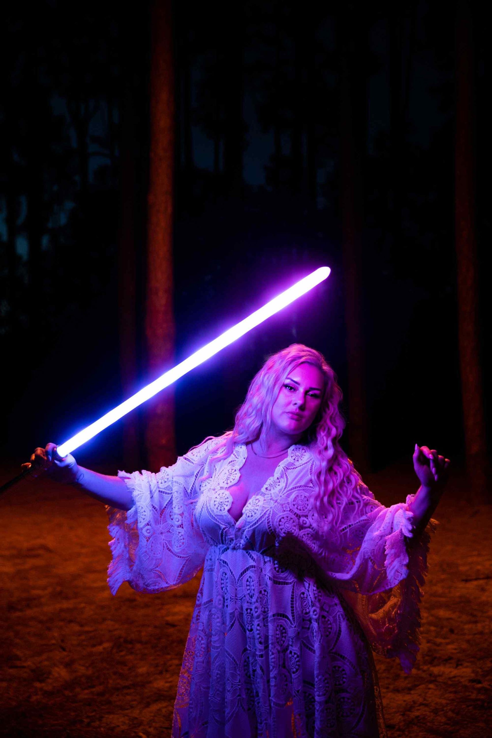 portrait of a woman posing with a lightsaber