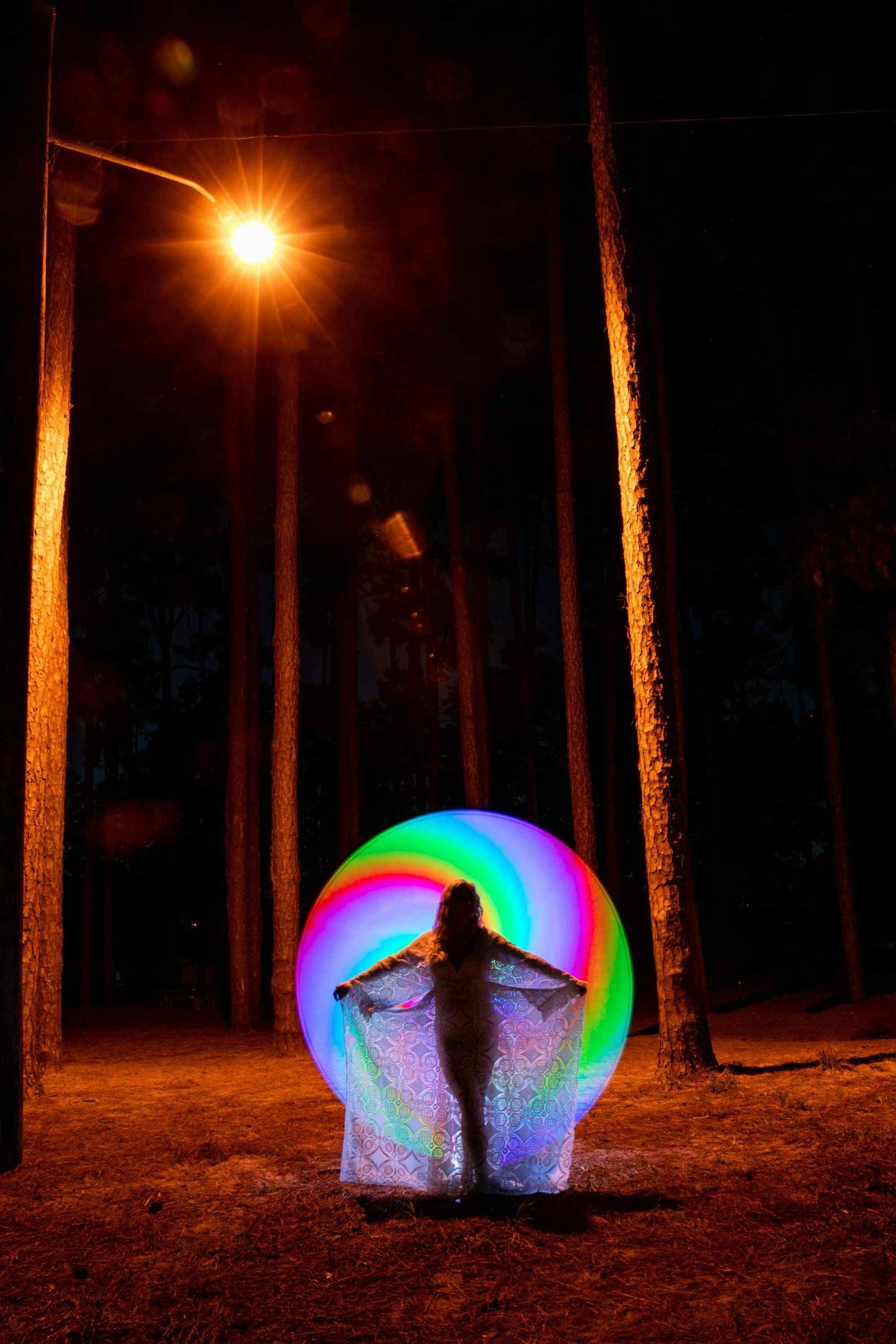 artistic photo of woman standing in front of light in the dark