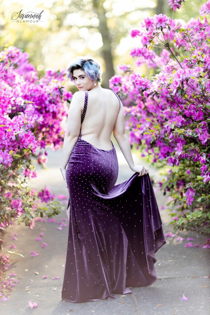 woman in a purple glamour gown in front of an azalea flower bush in Savannah