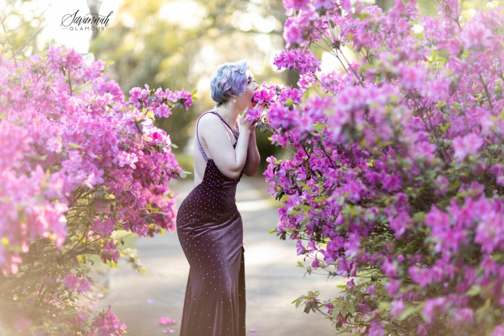 woman in a purple gown pretending to eat an azalea flower bush in Savannah