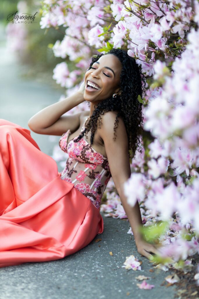 woman in a glamour gown laughing beside azalea bush in Savannah