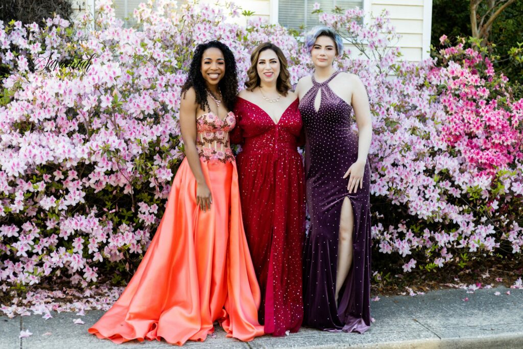 3 women in glamour gowns in front of azalea flower bushes in Savannah